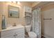 Neutral bathroom featuring a single vanity sink, medicine cabinet, toilet and walk-in shower with curtain at 10516 Mira Vista Dr, Port Richey, FL 34668