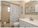 Bathroom featuring vanity, toilet, shower and tub combination, decorated with nautical themed shower curtain and artwork at 10516 Mira Vista Dr, Port Richey, FL 34668