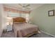 Cozy bedroom featuring neutral tones, a ceiling fan, and matching bedside tables with lamps at 10516 Mira Vista Dr, Port Richey, FL 34668