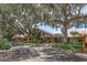 Exterior of a light colored building with a covered entrance surrounded by large trees with hanging moss at 10516 Mira Vista Dr, Port Richey, FL 34668