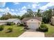 Charming single-story home featuring a well-maintained lawn, an attached garage, and colorful landscaping at 10516 Mira Vista Dr, Port Richey, FL 34668