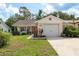Charming home featuring a well-manicured lawn, a single-car garage, and a quaint front yard with beautiful landscaping at 10516 Mira Vista Dr, Port Richey, FL 34668