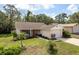 Inviting single-story home with a neat front lawn, mature trees, and an attached one car garage at 10516 Mira Vista Dr, Port Richey, FL 34668
