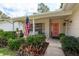 Charming front porch featuring an American flag, seating area, and view of lush front yard landscaping at 10516 Mira Vista Dr, Port Richey, FL 34668