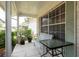 View of a tiled porch with a bench and table, surrounded by lush plantings at 10516 Mira Vista Dr, Port Richey, FL 34668