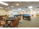 Spacious game room featuring pool tables, poker table, and ample seating at 10516 Mira Vista Dr, Port Richey, FL 34668
