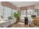 Well-lit home office space with large windows, hardwood floors, printer and ample desk space at 10516 Mira Vista Dr, Port Richey, FL 34668