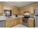 Bright kitchen featuring wood cabinets, stainless steel appliances, white countertops, and a garden window over the sink at 10516 Mira Vista Dr, Port Richey, FL 34668