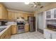Kitchen with stainless steel appliances, wood cabinets, and white tile flooring next to a pantry with custom cabinets at 10516 Mira Vista Dr, Port Richey, FL 34668