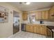 Traditional kitchen with light wood cabinets, white countertops, stainless steel appliances, and open access to the living area at 10516 Mira Vista Dr, Port Richey, FL 34668