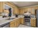 Bright kitchen featuring wood cabinets, stainless steel appliances, white countertops, and a garden window over the sink at 10516 Mira Vista Dr, Port Richey, FL 34668