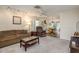 Inviting living room featuring neutral carpeting, a ceiling fan, and a comfortable seating arrangement at 10516 Mira Vista Dr, Port Richey, FL 34668