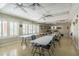 Bright meeting room featuring shuttered windows, ceiling fans, and long tables for gatherings at 10516 Mira Vista Dr, Port Richey, FL 34668