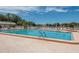 Inviting pool area with comfortable seating, umbrellas, and a scenic lake view at 10516 Mira Vista Dr, Port Richey, FL 34668