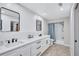 Modern bathroom with double sinks, quartz countertop, and a shower/tub combo with a shower curtain at 10825 Christopher Ct, Largo, FL 33774