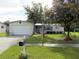 Beautifully landscaped single-story house with an attached garage and a lush green lawn at 11312 Brussels Boy Ln, Riverview, FL 33578