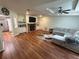 Open living room featuring hardwood floors, fireplace, and large sectional sofa at 11312 Brussels Boy Ln, Riverview, FL 33578