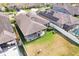 Aerial view of the backyard, including a covered patio, a large, grassy area, and white fencing at 11688 Brighton Knoll Loop, Riverview, FL 33579
