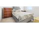 Comfortable bedroom featuring a tufted headboard, patterned bedding, and wooden dressers for storage at 11688 Brighton Knoll Loop, Riverview, FL 33579