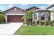 Charming single Gathering home featuring a stone facade accent and a well-maintained lawn with palms at 11688 Brighton Knoll Loop, Riverview, FL 33579