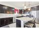 Modern kitchen with dark cabinets, stainless steel appliances, island, and granite countertops for a stylish cooking space at 11688 Brighton Knoll Loop, Riverview, FL 33579