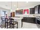 Modern kitchen featuring granite countertops, dark cabinetry, and seating for two at the kitchen island at 11688 Brighton Knoll Loop, Riverview, FL 33579