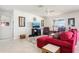 Bright living room with neutral tile flooring, comfortable red sectional, and classic leather armchairs at 11688 Brighton Knoll Loop, Riverview, FL 33579