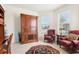 Cozy sitting area with two red armchairs, a wooden cabinet, and an area rug under natural light at 11688 Brighton Knoll Loop, Riverview, FL 33579