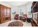 Charming sitting area featuring red upholstered chairs, a wooden cabinet, and a decorative rug at 11688 Brighton Knoll Loop, Riverview, FL 33579