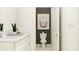 Modern bathroom with a white toilet and sink and framed art that gives the space a modern feel at 11845 Sparkling Topaz Cv, Parrish, FL 34219