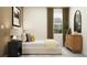 Serene bedroom with a neutral palette, dresser, bedside table, and natural light from the window at 11845 Sparkling Topaz Cv, Parrish, FL 34219
