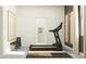 Bright exercise room with a modern treadmill, weights, and a view into an adjoining bathroom at 11845 Sparkling Topaz Cv, Parrish, FL 34219