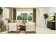 Spacious living room has a large window, white sofas with gold pillows, and indoor plants at 11845 Sparkling Topaz Cv, Parrish, FL 34219