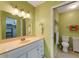 Bathroom with green-painted walls featuring a vanity and a mirror with vanity lighting at 120 Cedarwood Cir # 120, Seminole, FL 33777
