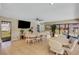 Well-lit community room with tile floors, tables, chairs, TV, lush plants, and large windows at 120 Cedarwood Cir # 120, Seminole, FL 33777