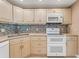 Kitchen features white cabinets, modern appliances, and a stylish backsplash, creating a clean and functional space at 120 Cedarwood Cir # 120, Seminole, FL 33777