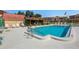 Community pool with clear blue water, lounge chairs, umbrella tables, and beautiful landscaping at 120 Cedarwood Cir # 120, Seminole, FL 33777