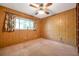 Bedroom featuring wood paneling, carpet and a ceiling fan with a light at 1242 Nelson St, Dunedin, FL 34698