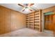 Bedroom with light brown carpet, a large bookcase, and wood paneling at 1242 Nelson St, Dunedin, FL 34698