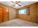 Bedroom featuring wood paneling, carpet and a window with patterned curtains at 1242 Nelson St, Dunedin, FL 34698
