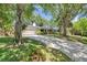 Beautiful single story home with mature trees and a long brick driveway at 1242 Nelson St, Dunedin, FL 34698