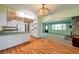 Well-lit kitchen showcasing sleek white cabinetry, a breakfast bar, and hardwood flooring at 1242 Nelson St, Dunedin, FL 34698