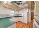 Kitchen features retro cabinetry, laminate countertops, and wood-look flooring at 1242 Nelson St, Dunedin, FL 34698