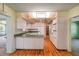 Eat-in kitchen with wood floors, white cabinets, and vintage overhead lighting at 1242 Nelson St, Dunedin, FL 34698