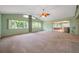 Bright living room with a ceiling fan, large windows, and a glimpse of an enclosed patio at 1242 Nelson St, Dunedin, FL 34698