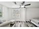 Bright bedroom featuring a ceiling fan, wood-look floors, a sitting area, and natural light from the window at 1247 21St St, Sarasota, FL 34234