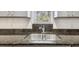 A stainless steel sink is nestled beneath a window, atop the granite countertop and grey cabinets in this bright kitchen at 1247 21St St, Sarasota, FL 34234