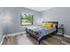 Well-lit bedroom boasts a large window and wood-look flooring at 1278 Mission Cir # 45B, Clearwater, FL 33759