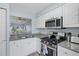 Bright kitchen with white cabinets, granite countertops, and stainless steel appliances offers a modern design at 1278 Mission Cir # 45B, Clearwater, FL 33759