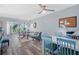 Bright living room with open floorplan with gray wood floors is furnished with stylish floral sofa and vibrant chairs at 1278 Mission Cir # 45B, Clearwater, FL 33759